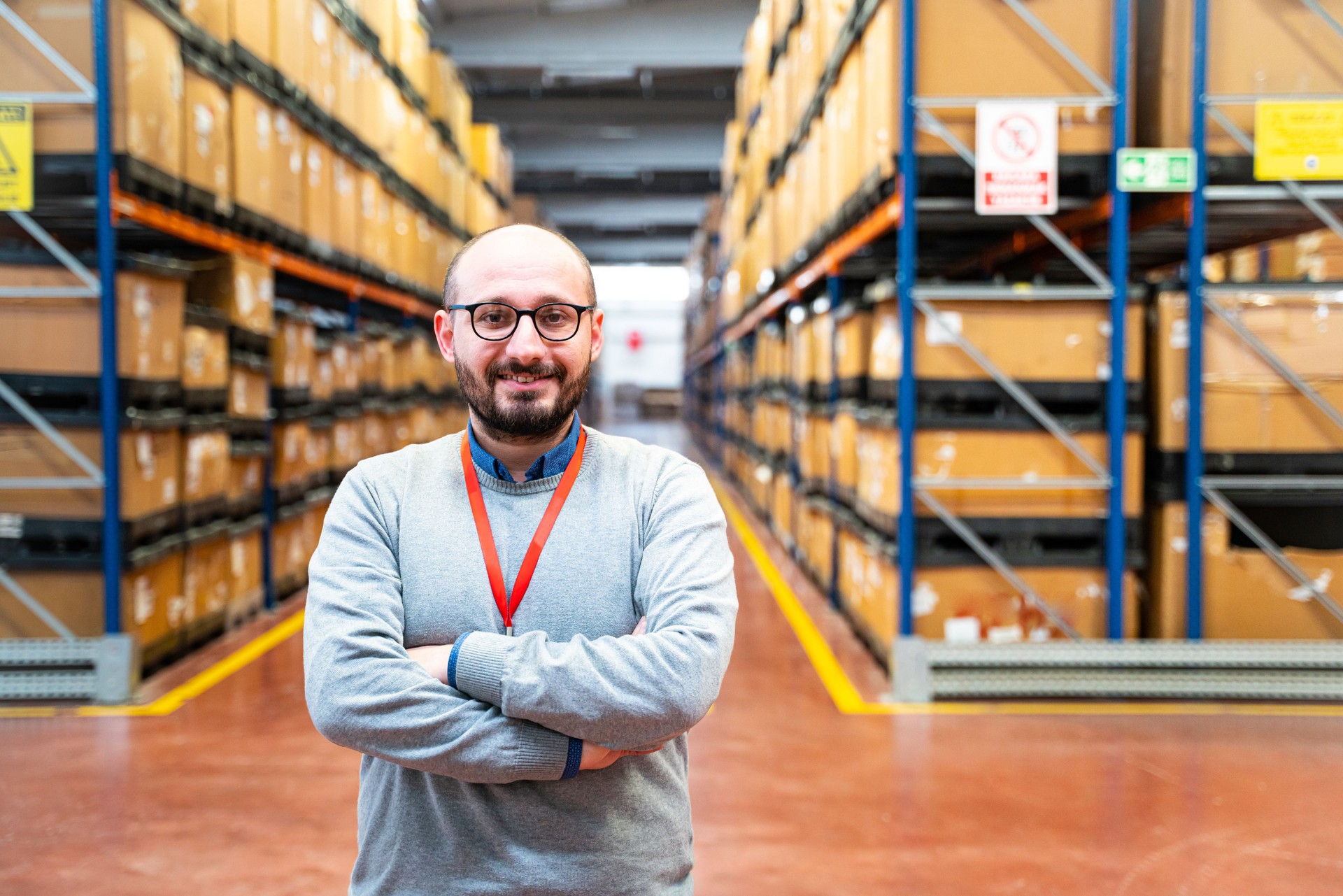 Portrait of a smiling businessman standing in corridor of warehouse