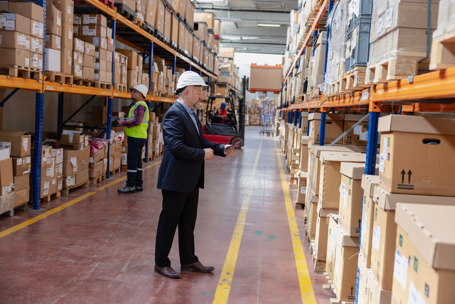 Factory manager using a digital tablet in a warehouse